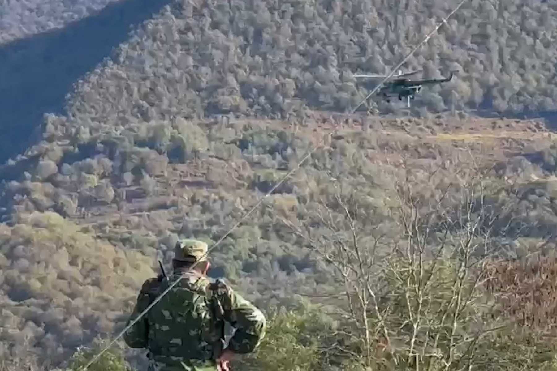 A helicopter and soldier taking part in the search. Screengrab via Apsny Yakhya