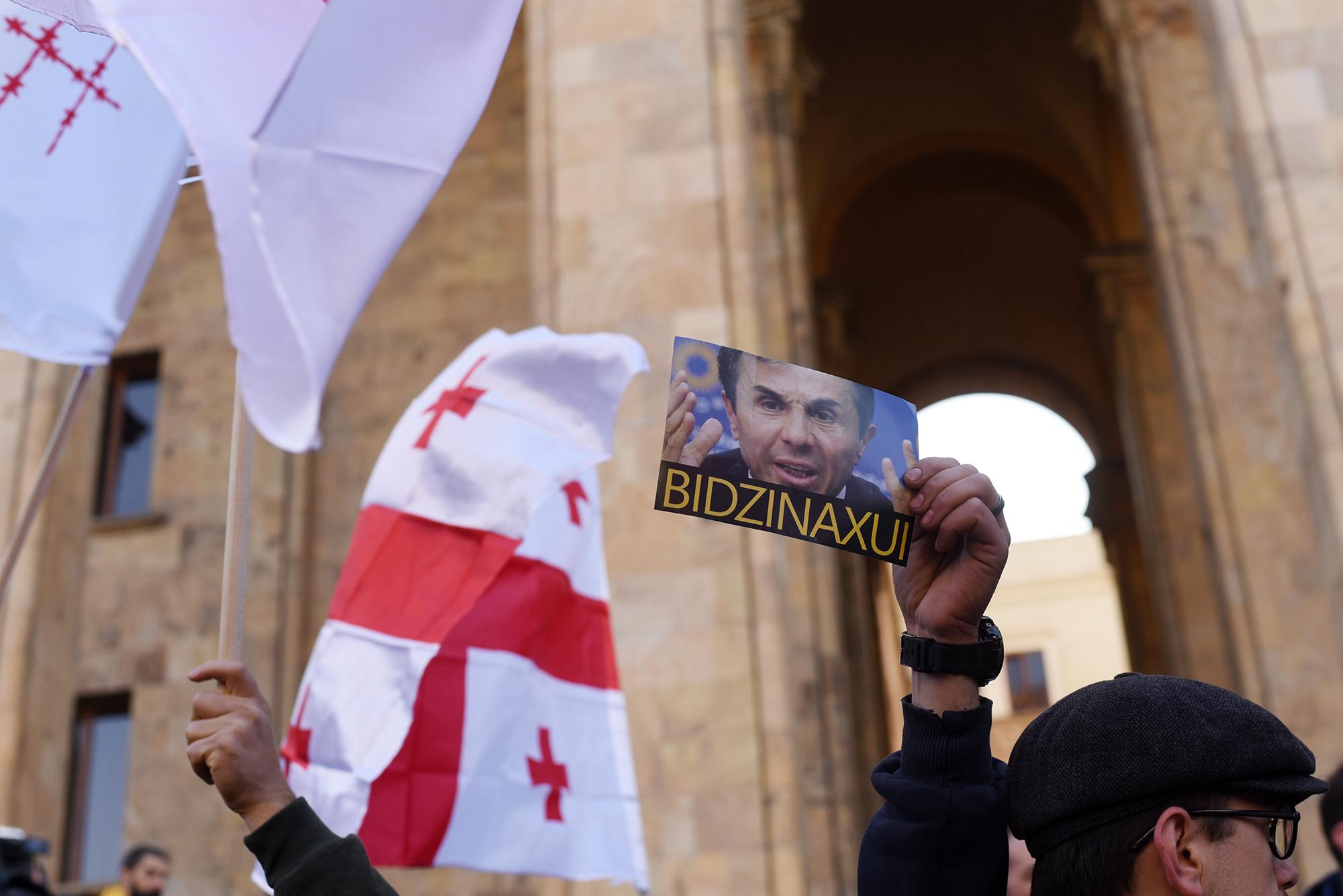 A protester holds a poster saying ‘Fuck Bidzina’ in Russian outside parliament on Sunday. Photo: Mari Nikuradze/OC Media.