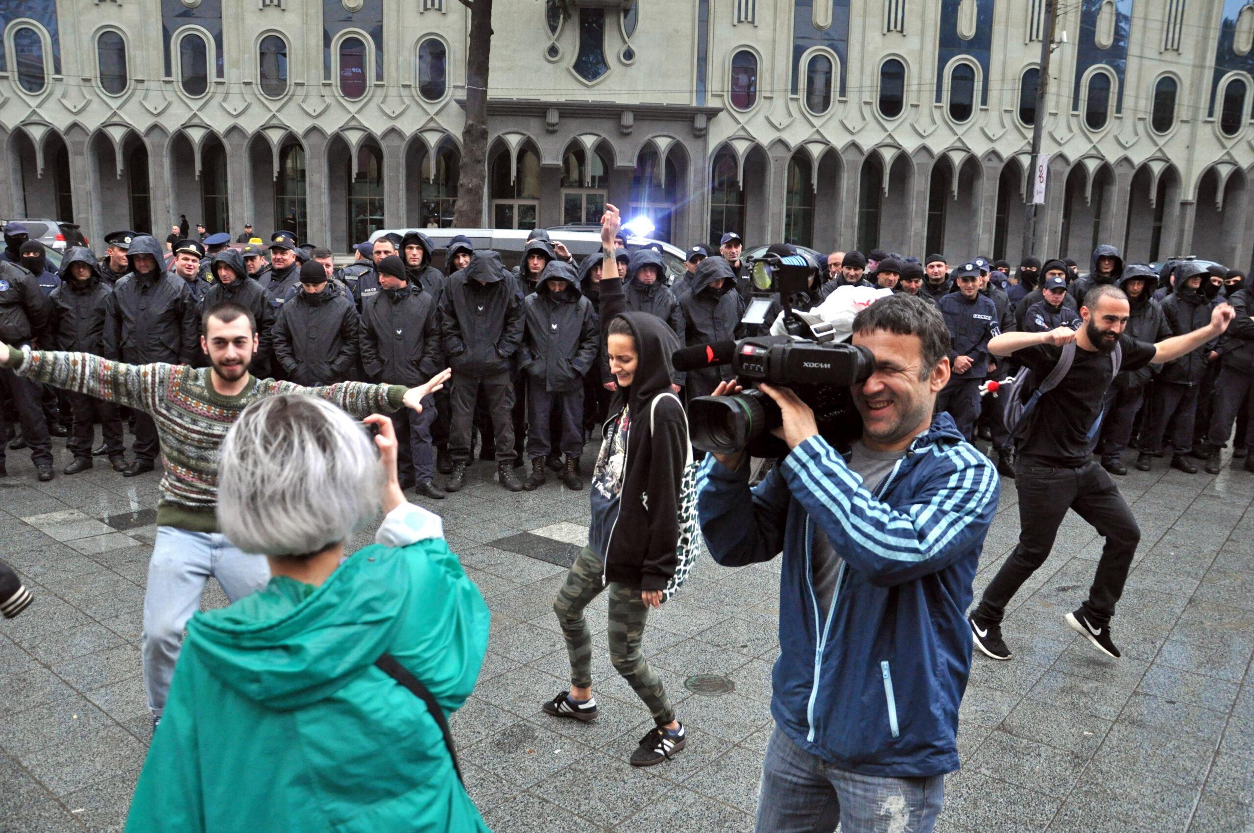 Activists dance in front of police a few hours after raids. (Mari Nikuradze/OC Media)